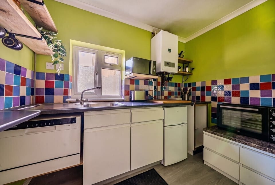 The fully equipped kitchen brings colour to every meal with its vivid tiled splashback.
