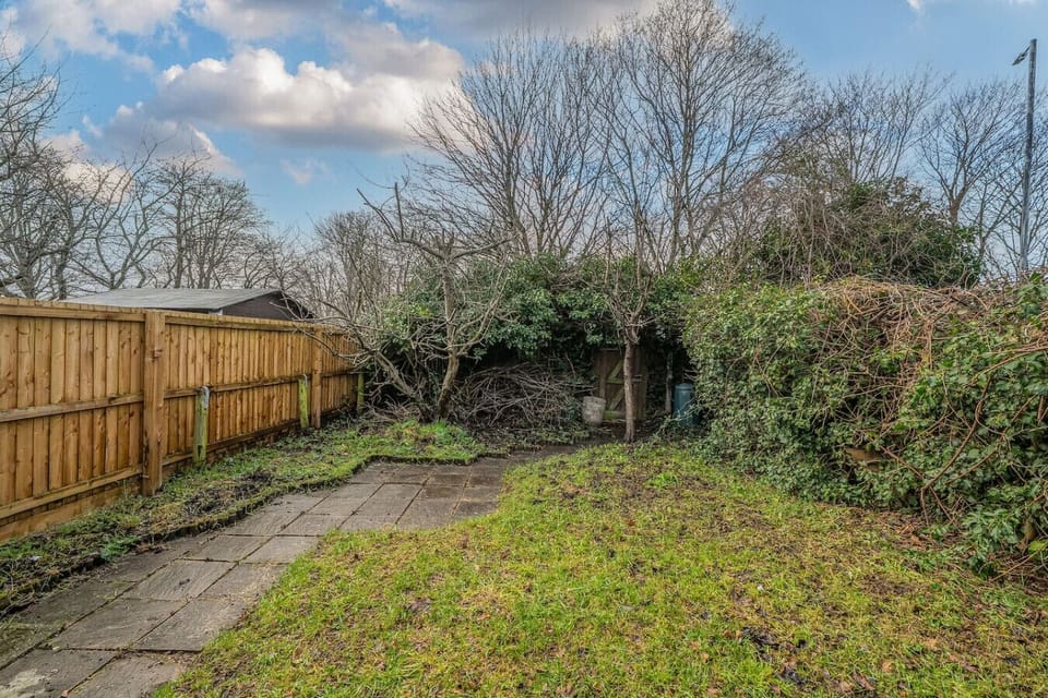 Step outside to a private garden with a paved patio area and lawn