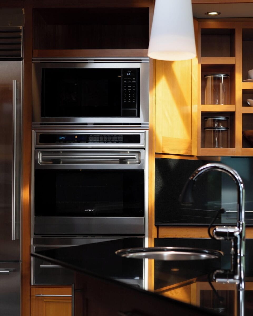 Prepare gourmet meals in your fully equipped kitchen featuring professional Wolf appliances, gleaming granite countertops, and warm wood cabinetry.