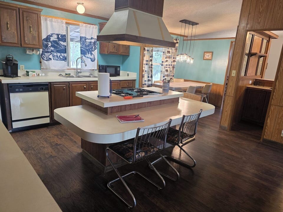 Wet bar with sink and stools, open to the kitchen.