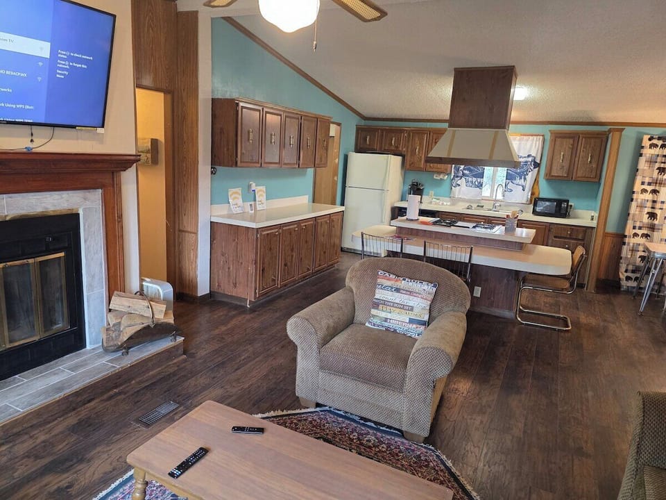 Living room with a large leather sectional and views to the pines.