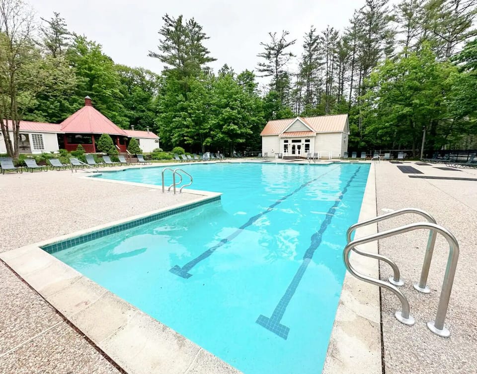 A view of outdoor pool open Memorial-Labor Day. There is a lap lane & hot tub.