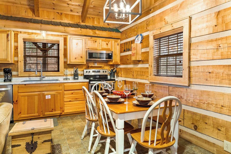 Gather around a rustic wooden table for 6, set beside a cozy stone fireplace.