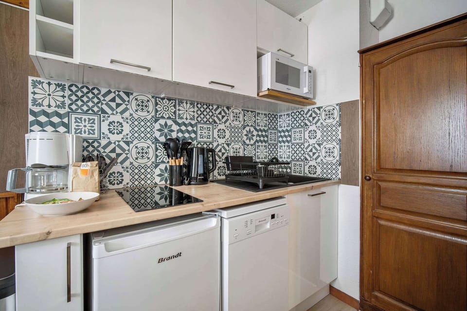 Fully equipped modern kitchen — dishwasher, ceramic hob, coffee maker, raclette grill — everything for your mountain stay.