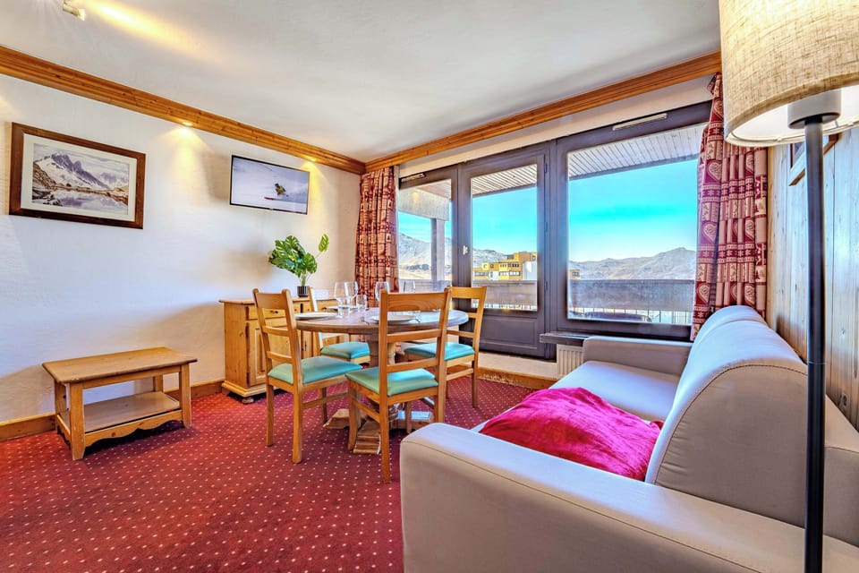 Bright living room with mountain views and dining space—steps from the pistes and lifts; cozy après-ski moments in Val Thorens, Les Belleville.