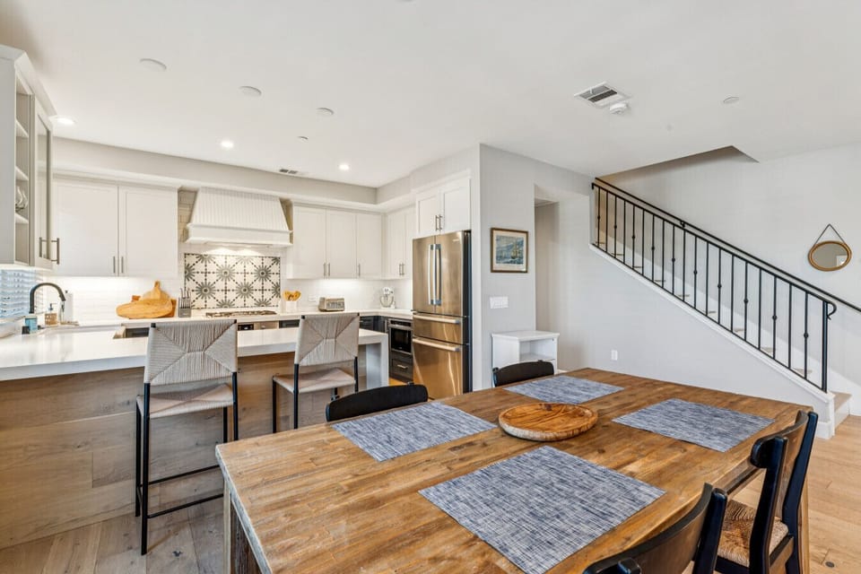 Dining area w/ large table flowing seamlessly into the kitchen & living space