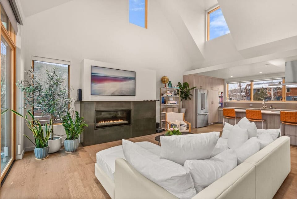Open Kitchen/Living Area/Dining Area with High Ceilings, TV, Fireplace & Large Windows & Sliding Doors to Backyard