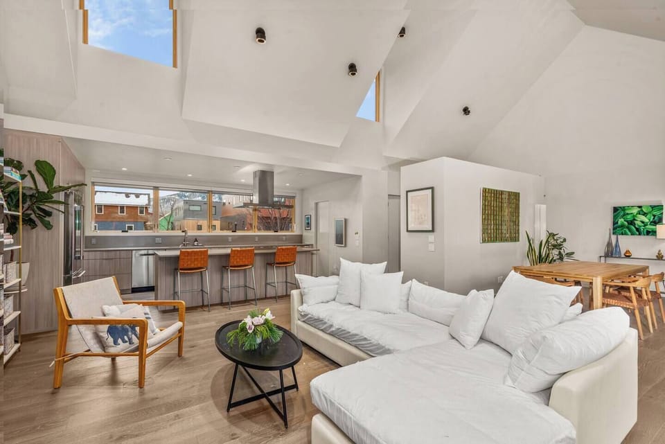 Open Kitchen/Living Area/Dining Area with High Ceilings, TV, Fireplace & Large Windows & Sliding Doors to Backyard