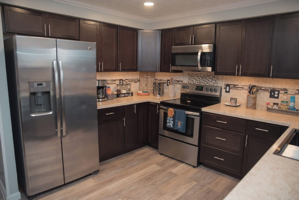 Modern kitchen with stainless steel appliances and sleek dark cabinetry.