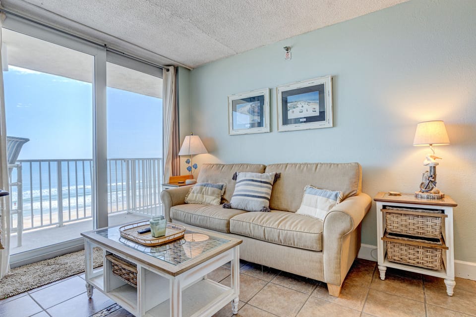 Relax in this bright coastal living room featuring ocean views, beach-inspired décor, and direct balcony access. Perfect for a beach stay, this inviting space offers comfort, natural light, and a front-row seat to the shoreline.