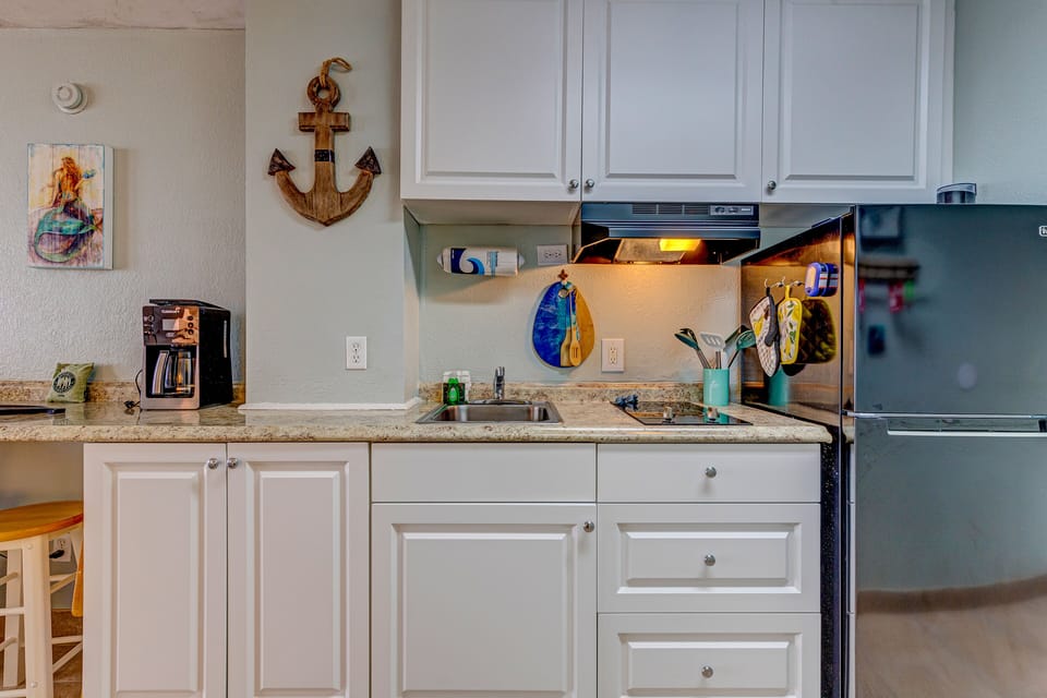 This bright beach-themed kitchenette offers everything you need for a relaxing coastal stay, featuring modern appliances, nautical décor, and plenty of counter space for easy vacation meals.
