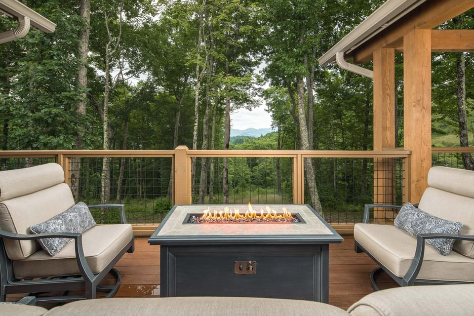 Covered deck with a gas fire table and Banner Elk mountain views
