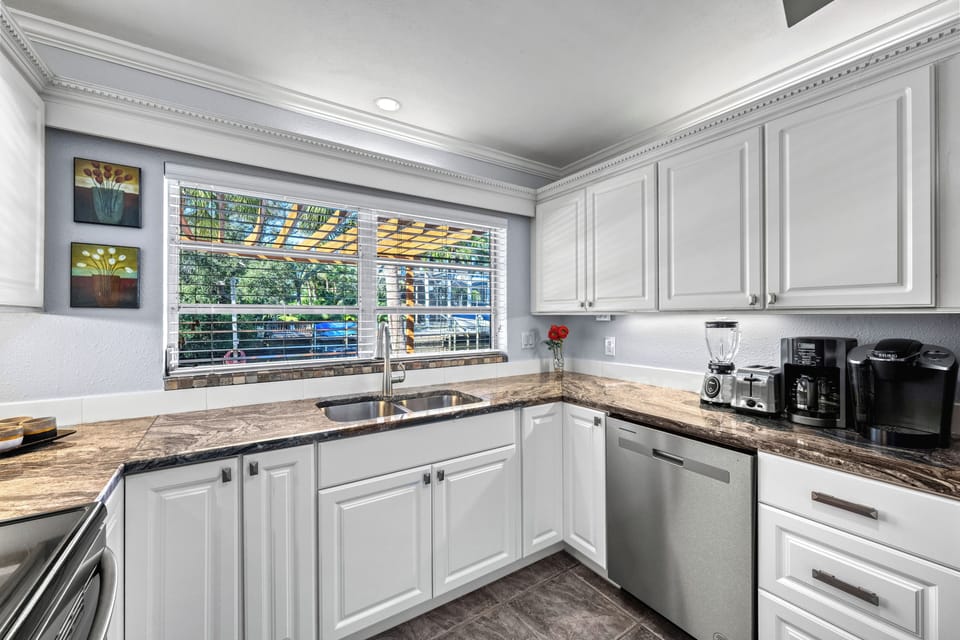 This open kitchen is stocked with the essentials such as a Keurig for your daily coffee.