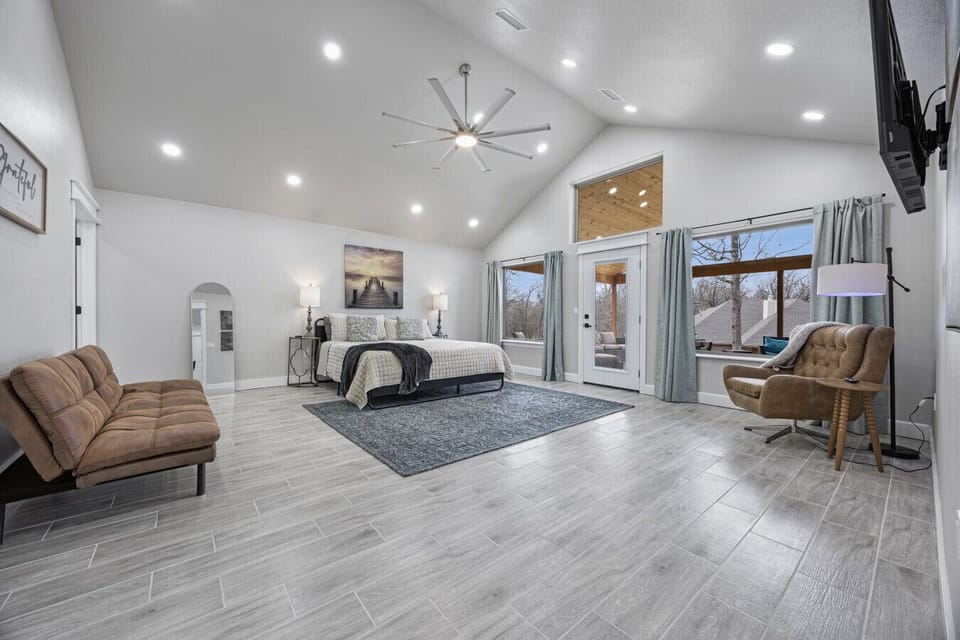 Primary bedroom with king bed, ensuite bathroom with shower, and access to the covered porch