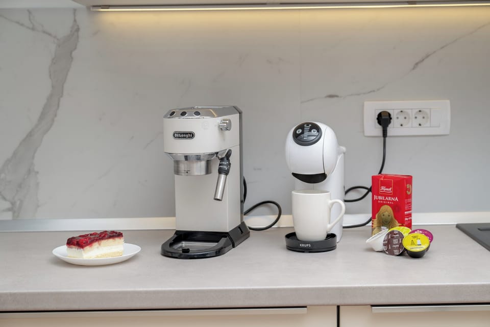 "Coffee corner with two machines and a sweet treat ready to enjoy."