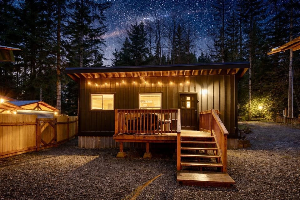 Cozy cabin retreat with warm outdoor string lights and deck