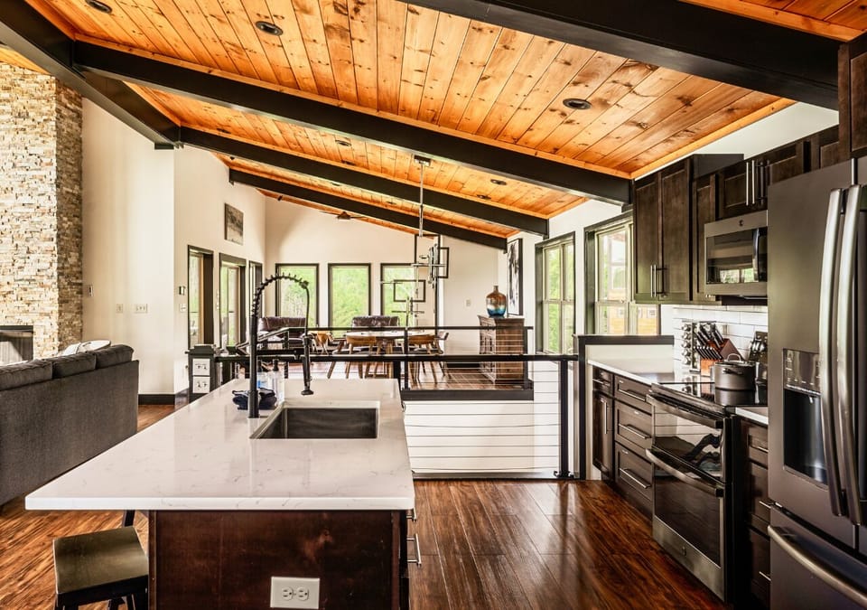 pacious open-concept kitchen with island and wood-beam ceilings