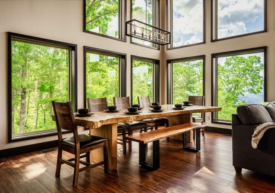 Dining area with floor-to-ceiling windows and forest views