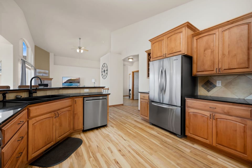 Cook your favorite meals in this fully-equipped kitchen with granite counters, stainless appliances, and warm wood cabinets.