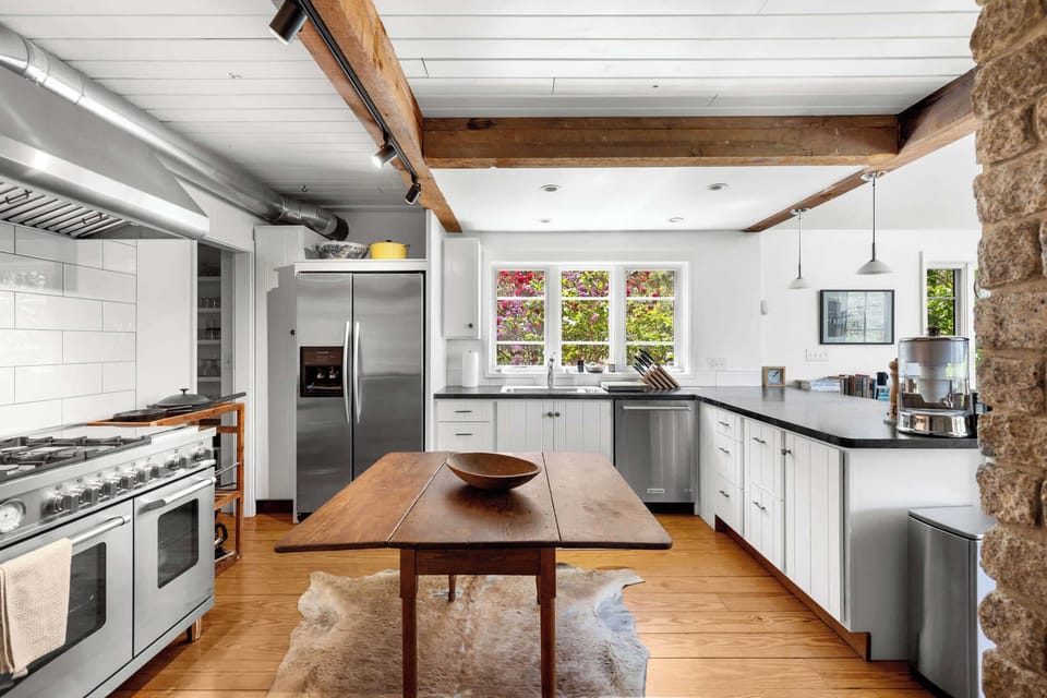 Gourmet kitchen with professional style range, double ovens, stainless appliances, and bright windows for relaxed Cape Cod cooking.