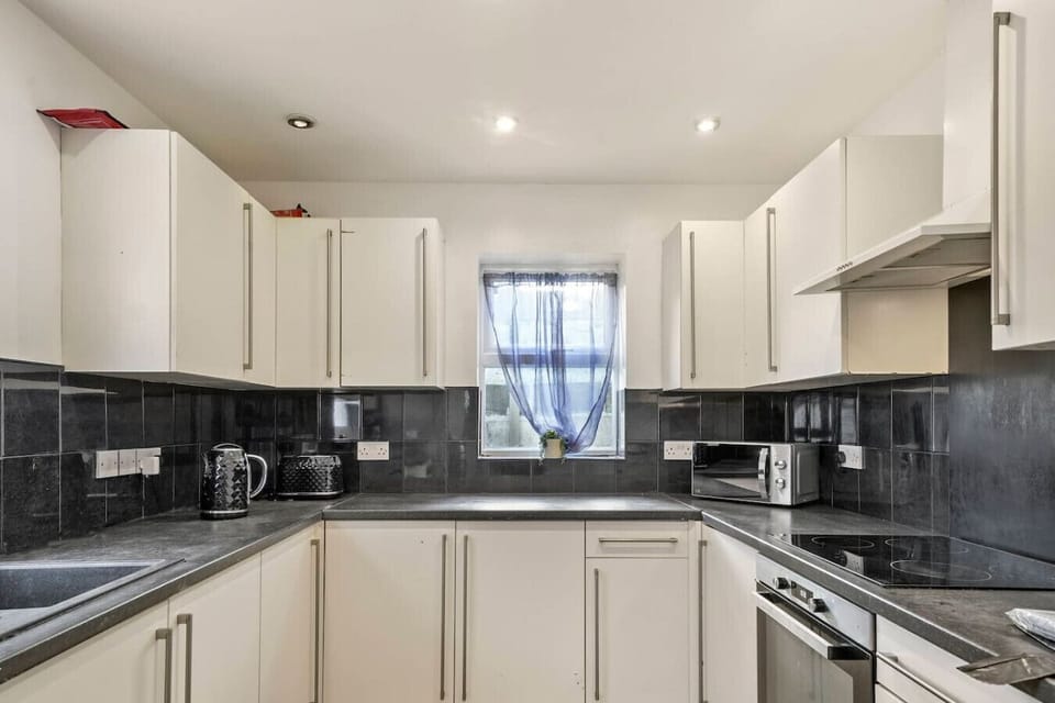 Prepare meals easily in the bright kitchen with wraparound counters and glossy cabinets.
