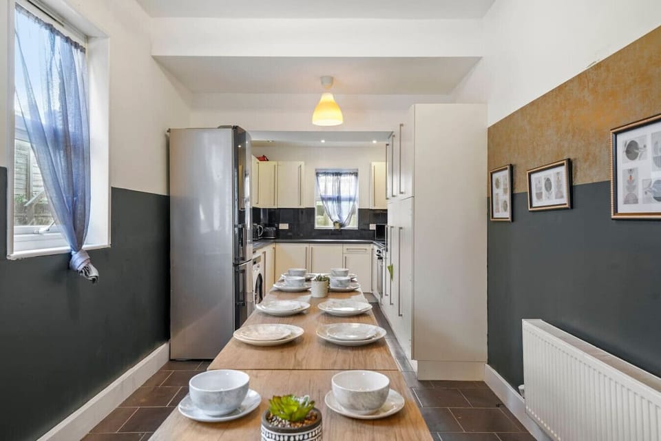 Gather around the long table for group meals with the kitchen visible at the far end.