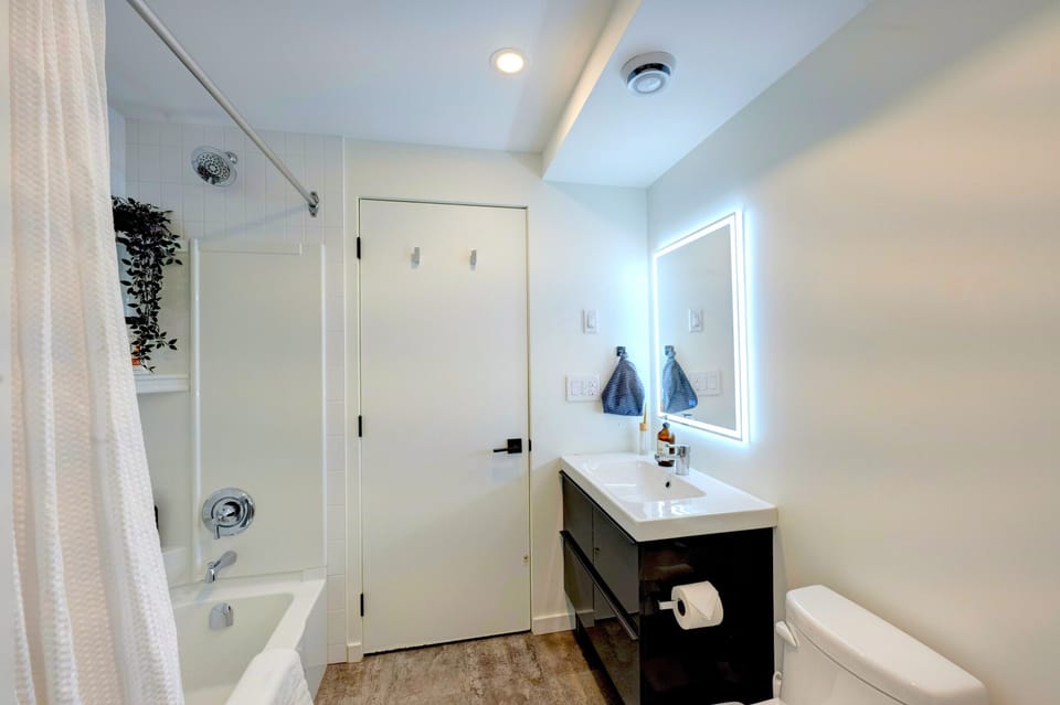 Full bathroom with modern vanity, tub/shower combo, and spa-style finishes.