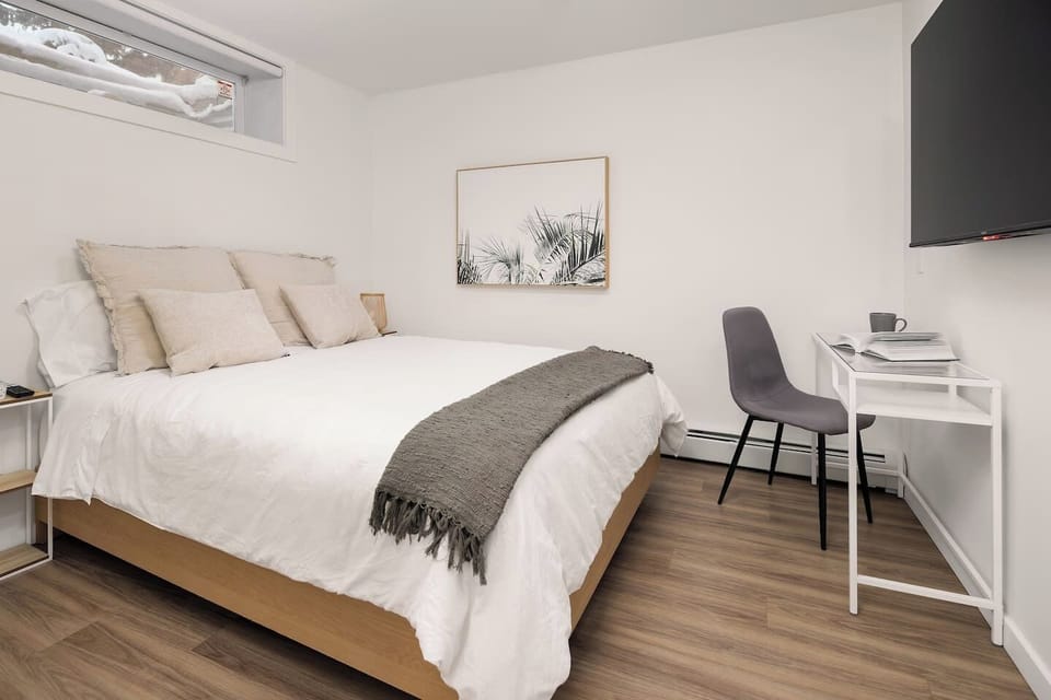 Bedroom with queen bed, workspace, and Smart TV for streaming.