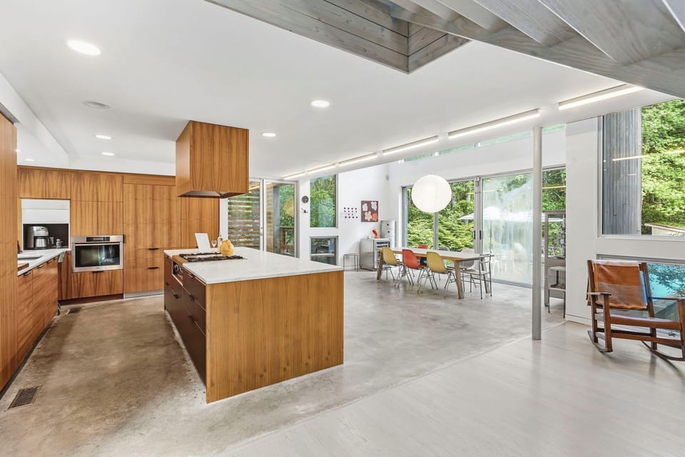 Kitchen with wood cabinetry, gas cooktop, and marble island