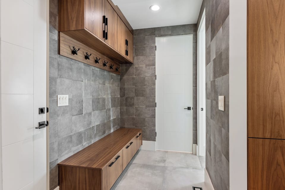 Well-designed mudroom featuring built-in bench seating, hooks, and storage cabinets—ideal for organizing coats, boots, and outdoor gear after mountain adventures.