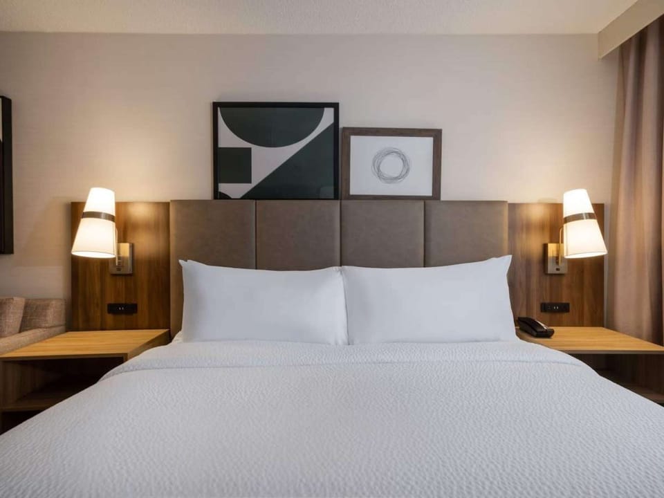 Close-up of bed with padded headboard and bedside lights