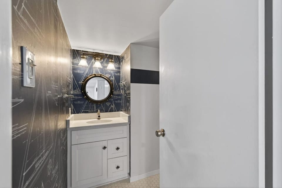 Stylish bathroom with modern vanity, round mirror, and bold accent walls. Clean finishes and bright lighting create a fresh, contemporary space for daily routines.