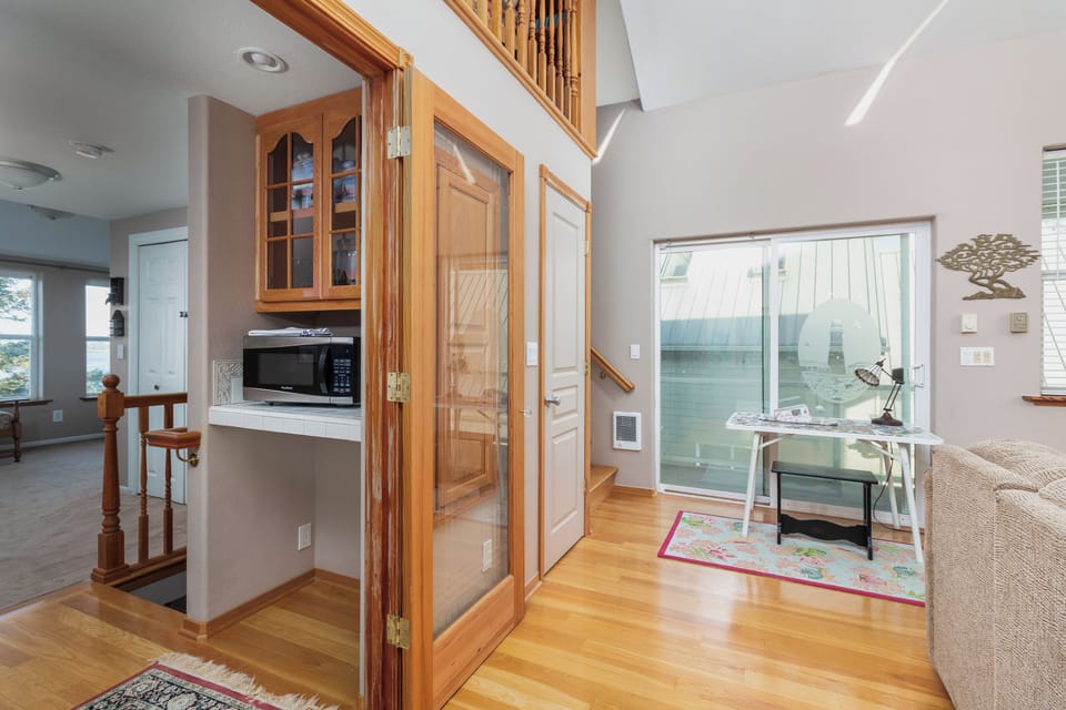 Your bright open-plan living space features rich wood cabinetry, modern appliances, and a cozy desk nook by the window for peaceful moments.