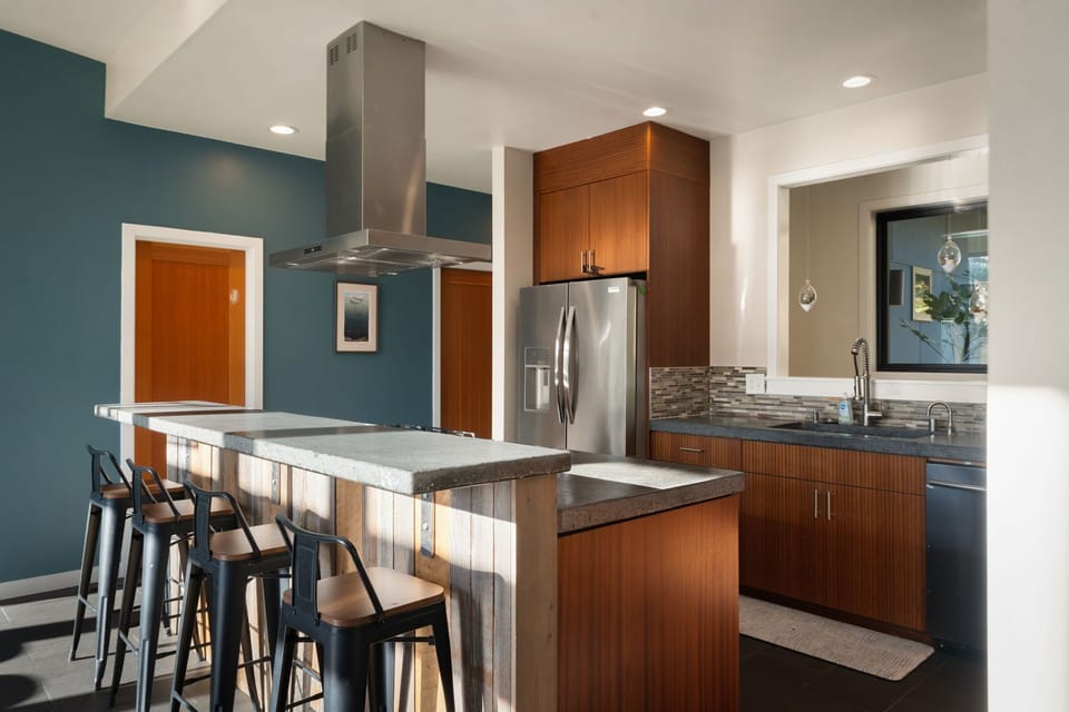 Your modern kitchen awaits with sleek appliances, warm wood finishes, and a breakfast bar where you can sip morning coffee.