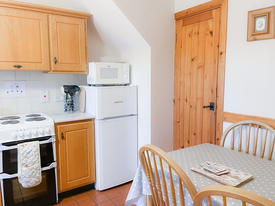 Tuskar Holiday Cottage, Mill Road Farm. Small fitted pine kitchen with dining table.