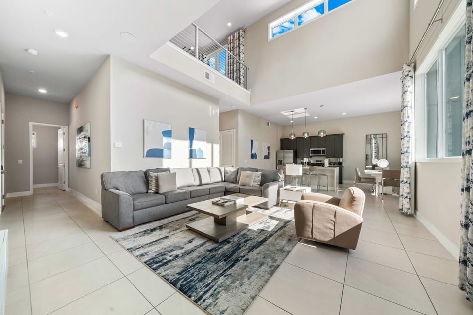 Large sectional and leather accent chair centered around a 65” smart TV—perfect for relaxing together.