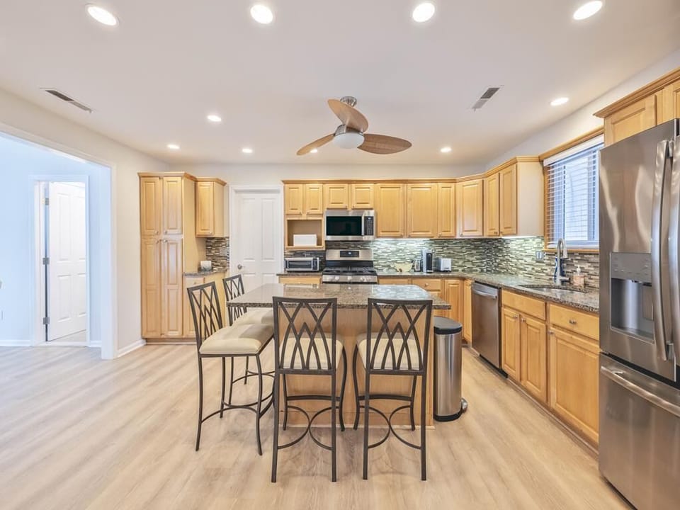 Spacious kitchen featuring modern appliances, generous cabinetry, and a large island with seating.