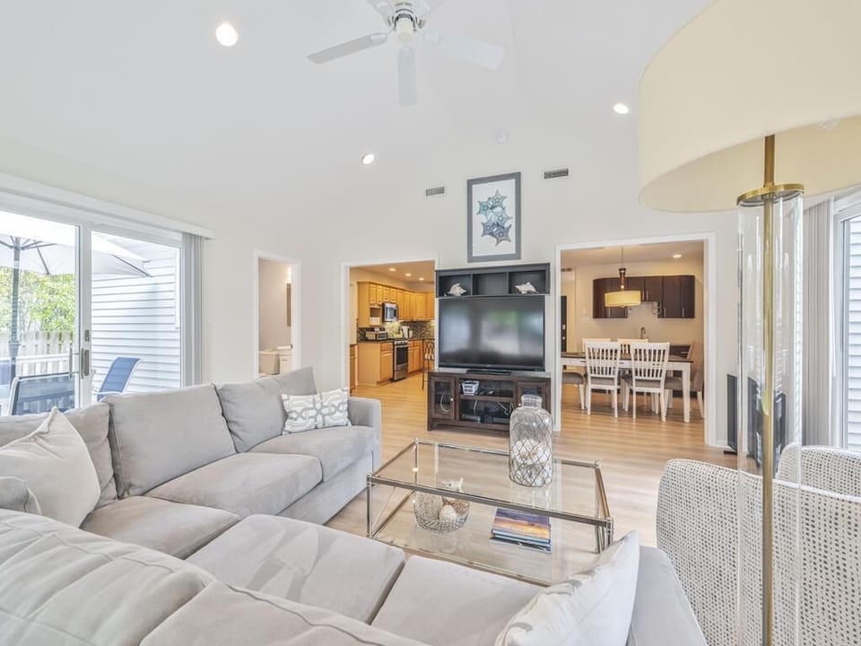 Spacious living area with a comfortable sectional sofa, modern coffee table, and an open flow into the dining space.