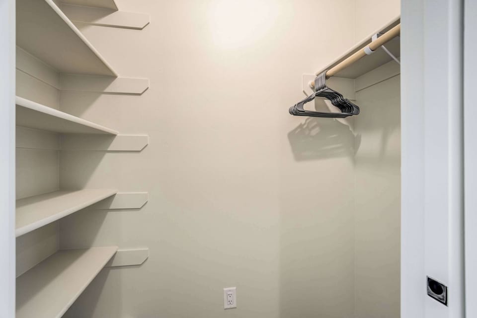 A spacious walk in closet with built in shelving provides plenty of room for your luggage and wardrobe. This thoughtful addition ensures your private suite remains organized and clutter free throughout your stay.