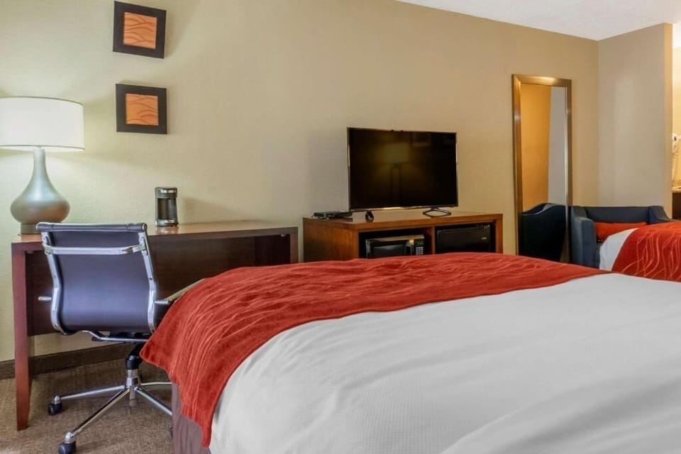 Unwind on crisp linens with desk and TV comfort.