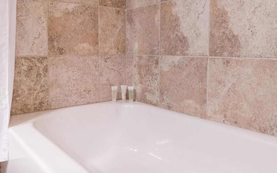 Soak and reset in a deep tub with warm tile surround.