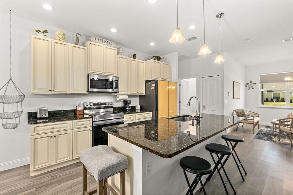 Large kitchen with generous counter space, island seating, and open layout