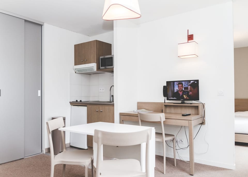 The open living space includes a dining table and seating, ideal for relaxing or sharing meals.