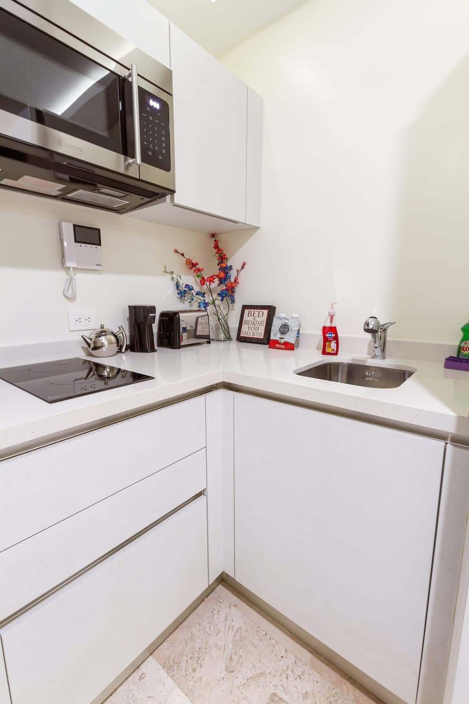The kitchen is equipped with an electric stove, microwave, coffee maker, and toaster. Everything is ready to make you feel at home.