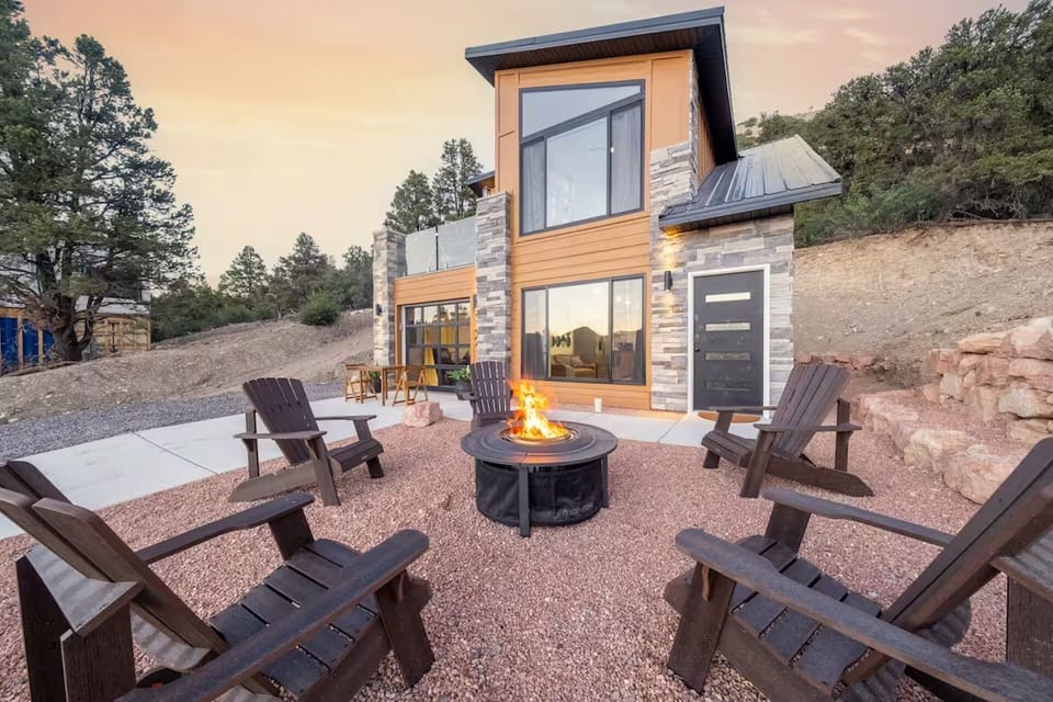 An exterior view of our home, the courtyard, the Adirondack chairs and fire pit 