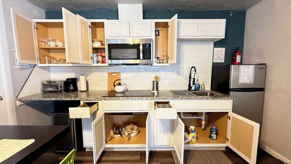 Everything’s within reach — pots, pans, glassware, and basic condiments, plus cleaning supplies to keep things tidy.