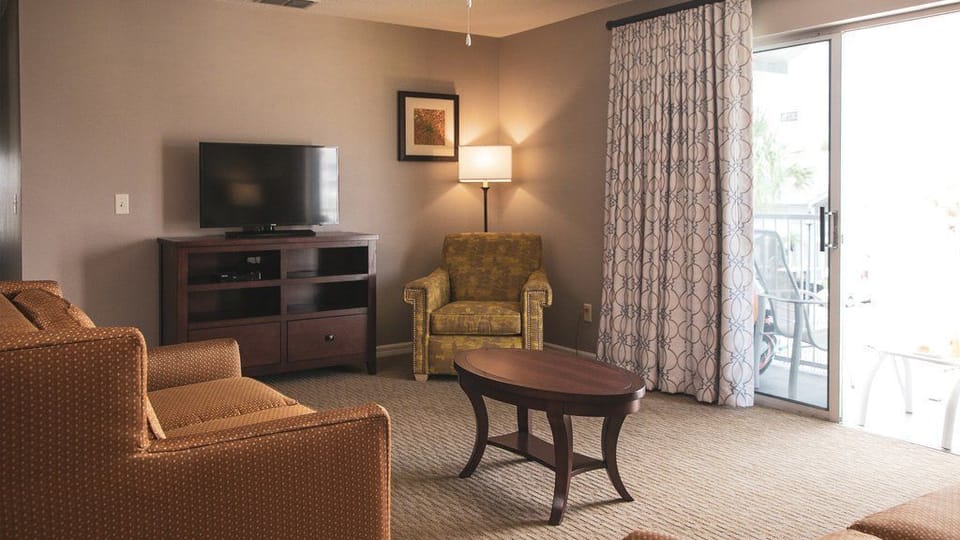 Relax in this spacious living area adorned with inviting seating and bright natural light, ideal for family gatherings and cozy movie nights, providing a perfect respite before heading out to the parks.