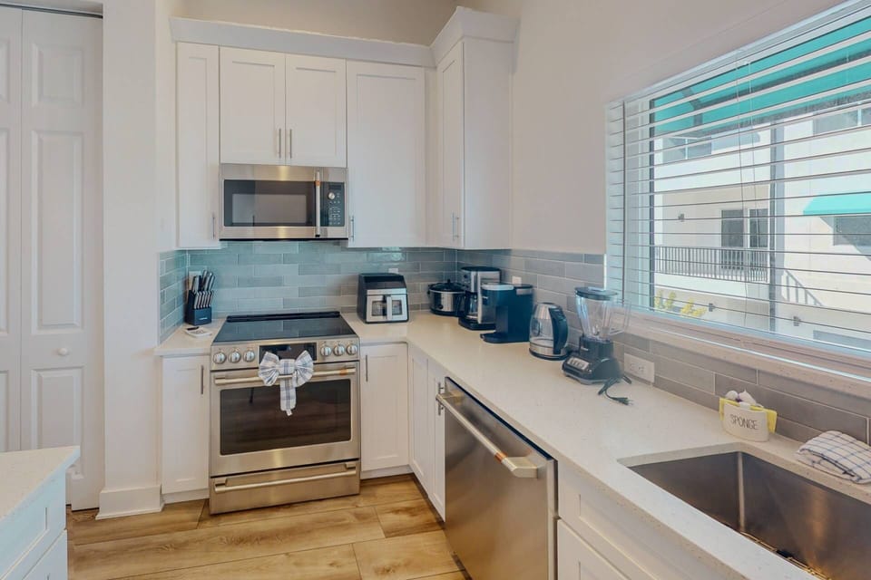 Fully equipped kitchen with high-end appliances, cookware, dishware, and utensils