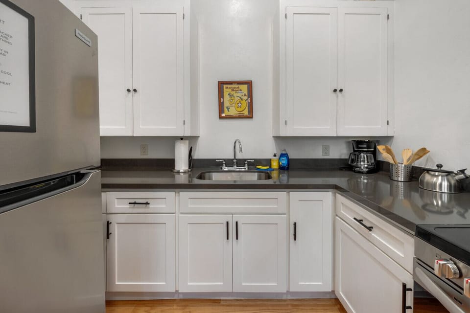 Small, but mighty kitchen space with cozy dining table, fridge, range, oven, and microwave (no dishwasher)