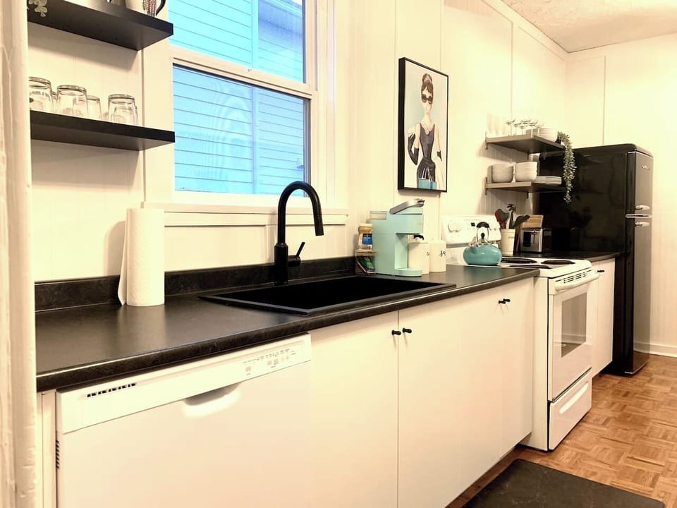 Fully equipped kitchen with stove, microwave, coffee maker, cookware, and dining essentials.